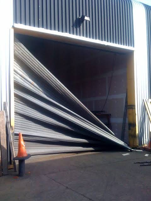 Severely damaged industrial roller shutter awaiting Empire Doors repair